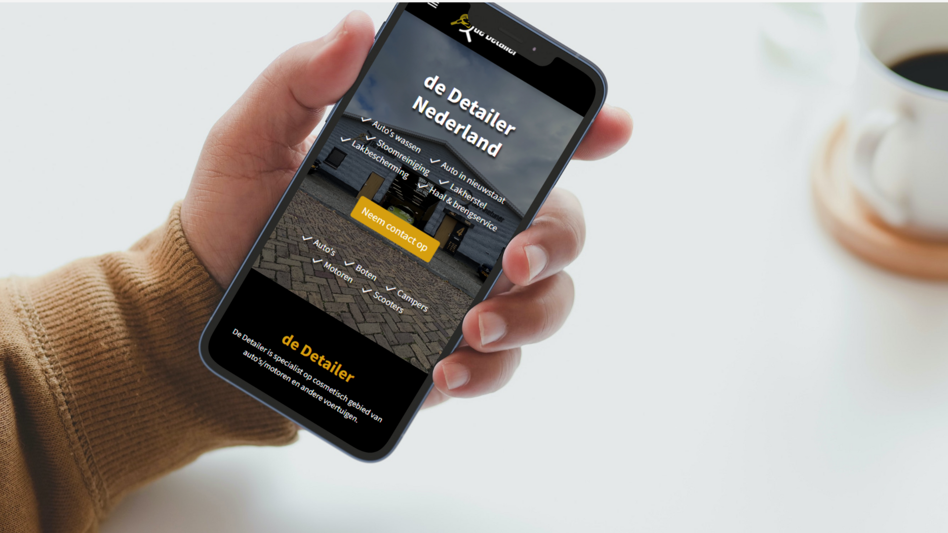 Website van De Detailer open op een telefoon in iemands hand